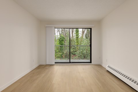 A room with a sliding glass door leading to a garden.
