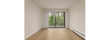 A room with a sliding glass door leading to a garden.