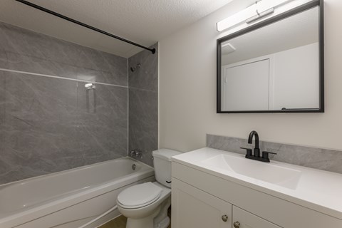 A bathroom with a white toilet and a white sink.
