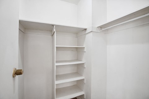 A white shelving unit with a brass door handle.