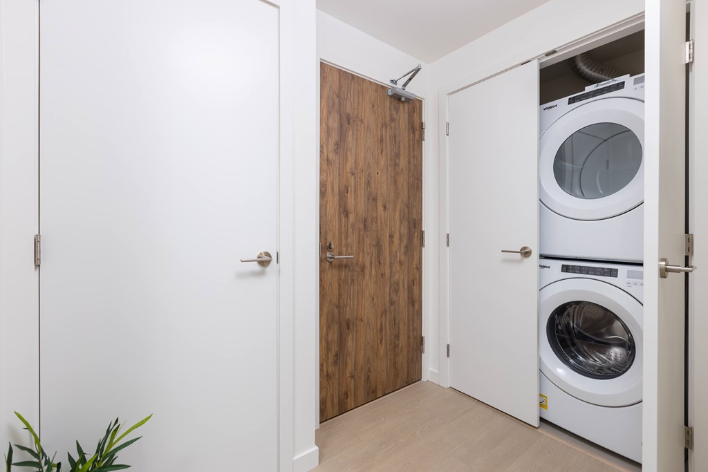 A white door is open to a laundry room with a washer and dryer.