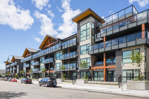 a large apartment building with cars parked in front of it