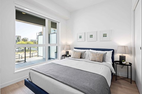 A bedroom with a large bed and a view of the outside.