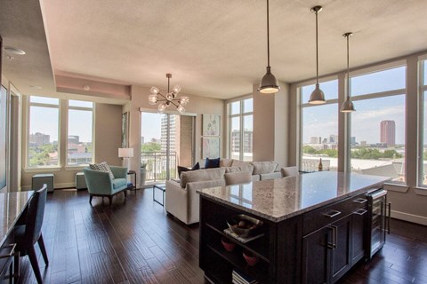 A kitchen with a large island and a dining table with chairs.