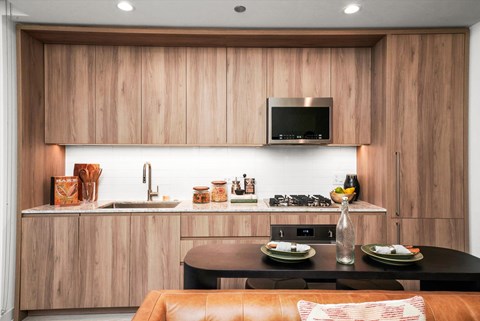 A modern kitchen with wooden cabinets and a black countertop.