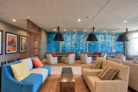 A living room with a blue couch and a brown coffee table.