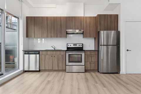A modern kitchen with wooden cabinets and stainless steel appliances.