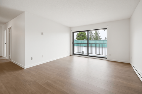 A room with a wooden floor and a balcony with a railing.