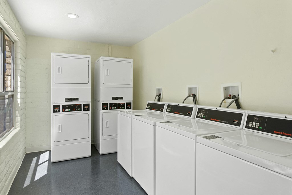 a laundry room with white washers and dryers