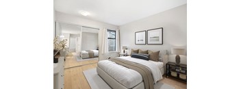 A bedroom with a large bed and a mirror on the wall.