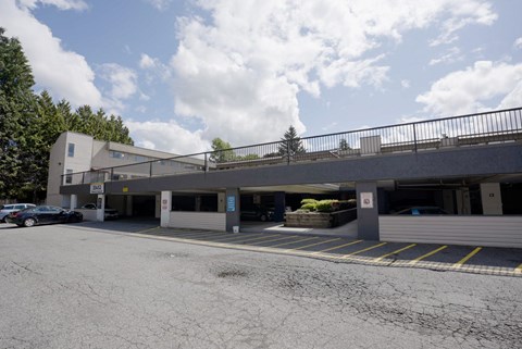 A parking lot with a building and cars.