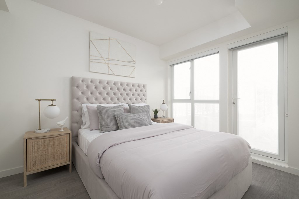a white bedroom with a large bed and a window