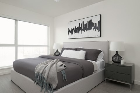 a black and white bedroom with a bed and a large window