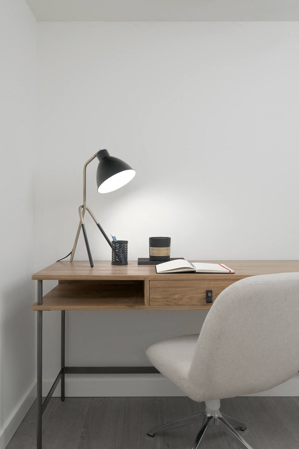 a desk with a lamp and a chair in a room