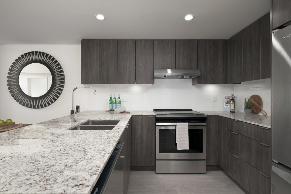 a modern kitchen with marble counter tops and wooden cabinets