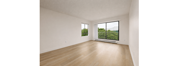 Empty room with a window overlooking a green landscape.