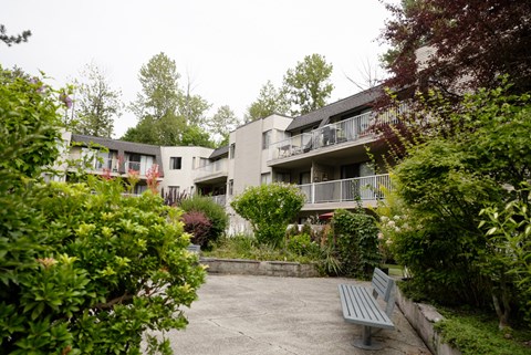 A grey bench sits in front of a building.