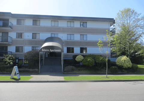 A building with the name "Relaie Apartments" on a sign in front of it.