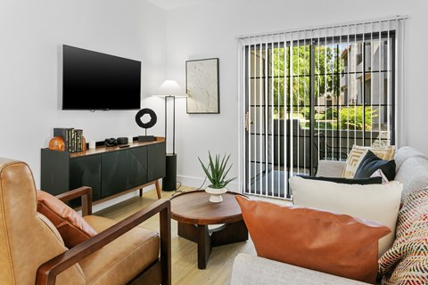 A living room with a brown leather chair, a wooden coffee table, and a white sofa.
