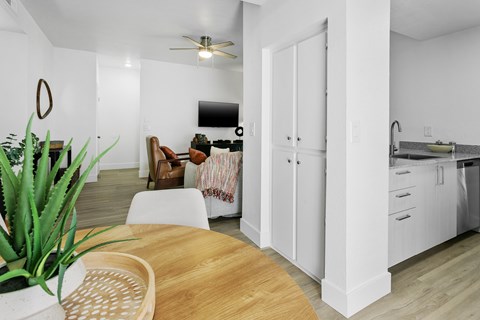 A living room with a couch, a chair, a table, and a potted plant.