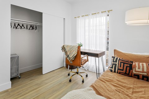 A room with a bed, a chair, and a table.