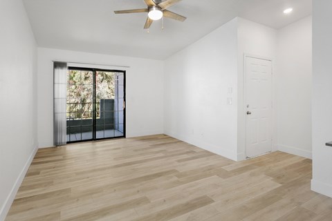 A room with a sliding glass door leading to a balcony.