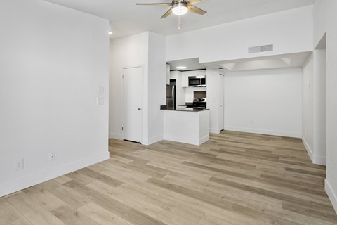 A room with a ceiling fan and wooden flooring.