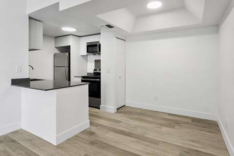 A kitchen with a white island and wooden floors.