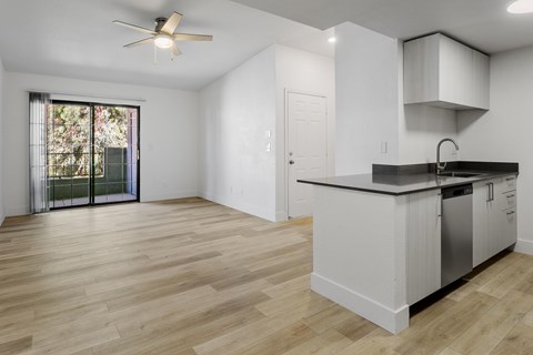 A kitchen with a white counter and wooden floors.