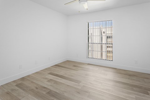 A room with a window and wooden flooring.