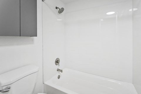 A white bathroom with a toilet, sink, and bathtub.