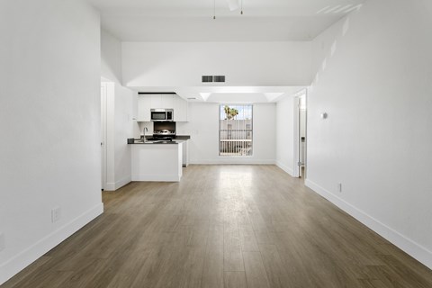 A kitchen with white cabinets and a wooden floor.