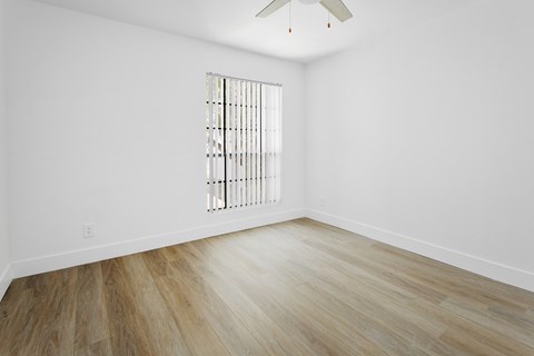 A room with a window and a ceiling fan.