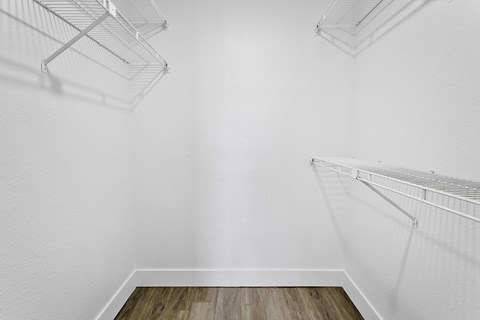 Empty white shelves in a room with wooden floor.