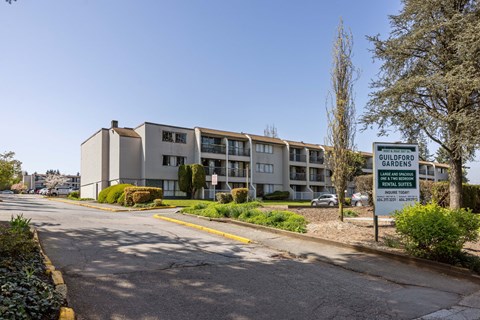 A street view of a building with a sign that reads Guildford Gardens.