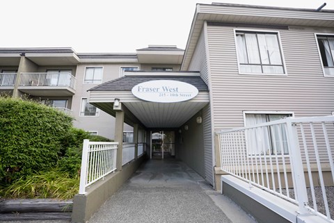 The entrance to Fraser West Apartments is covered by a white awning.