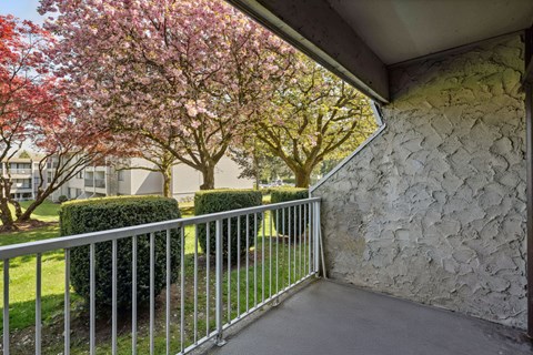 A balcony with a metal railing and a stone wall.