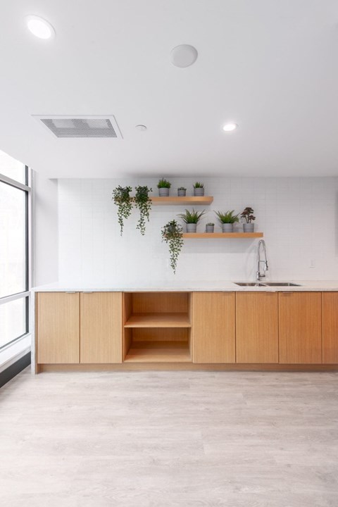 A kitchen with wooden cabinets and a white wall.