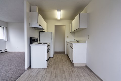 A kitchen with white appliances and cabinets.