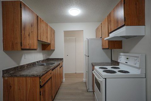 A kitchen with a white stove and wooden cabinets.