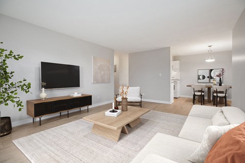 A living room with a white couch and a wooden coffee table.