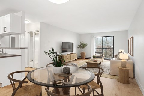 A modern living room with a glass table and brown chairs.