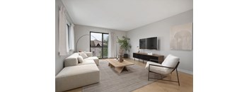 A living room with a white sofa, a wooden coffee table, and a television.