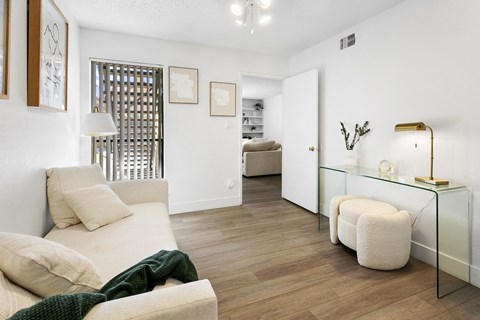 a living room with a white couch and a glass table