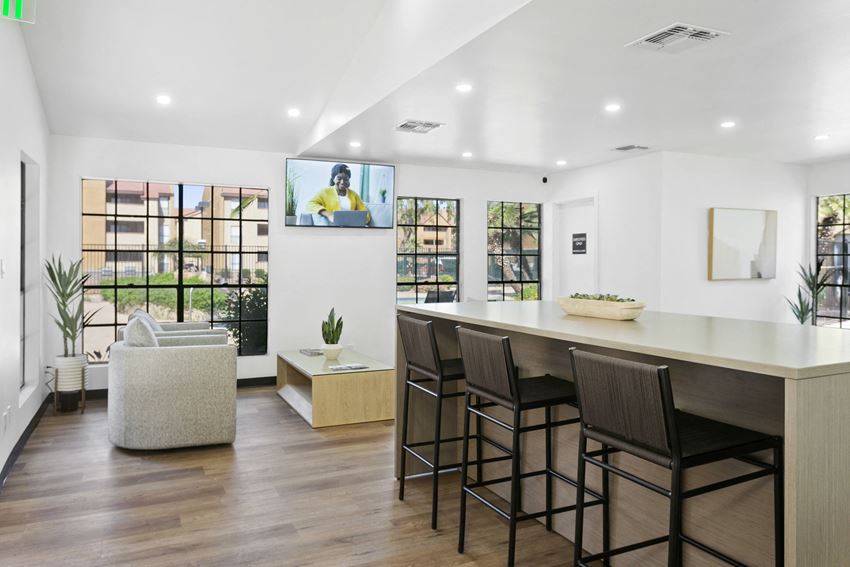 a room with a table and chairs and a television on the wall