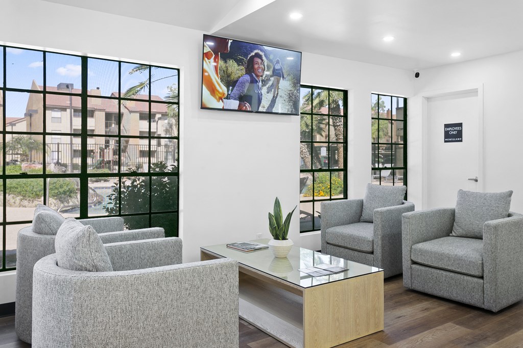 a room with couches and a coffee table with a flat screen tv on the wall