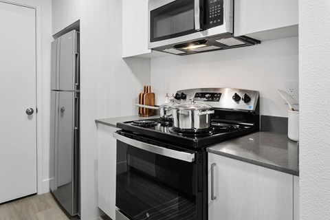A modern kitchen with a stove top oven and microwave above it.