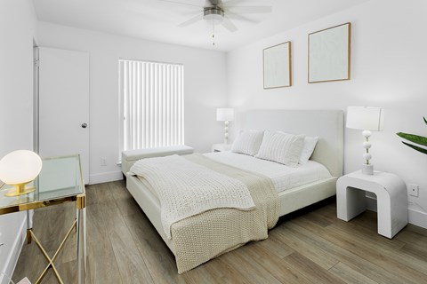A bedroom with a bed, nightstand, and a ceiling fan.
