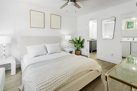 A white bedroom with a large bed and a ceiling fan.