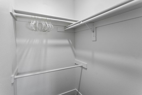 Empty white shelves with hangers.